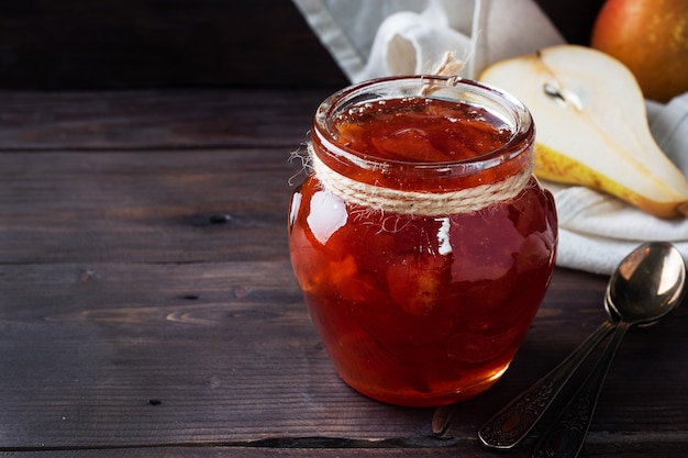 Mermelada de pera casera en un frasco y peras frescas