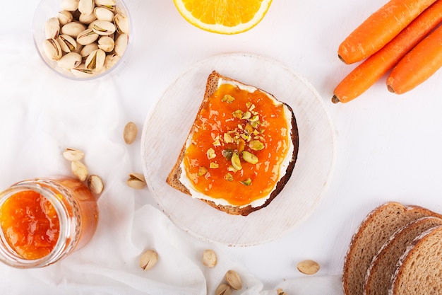 Mermelada de zanahoria con jugo de naranja sobre un fondo gris