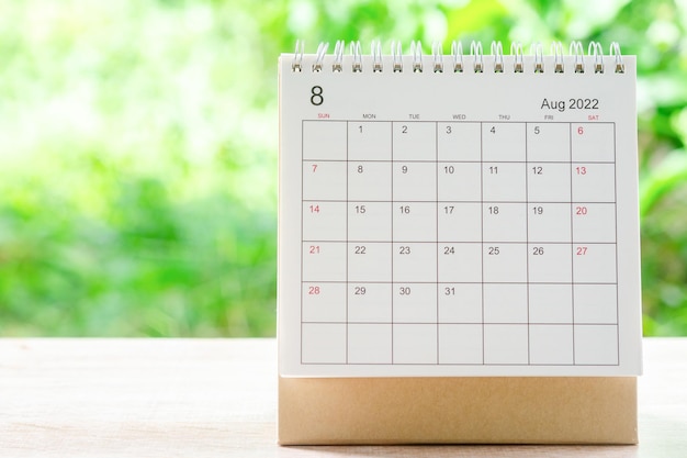 Mes de agosto, escritorio de calendario 2022 para organizador de planificación y recordatorio en mesa de madera con fondo de naturaleza verde.