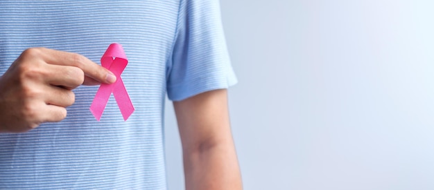 Mes de concientización sobre el cáncer de mama de octubre rosa El hombre sostiene la cinta rosa para apoyar la vida y la enfermedad de las personas Mes nacional de los sobrevivientes del cáncer Concepto del Día de la Madre y el Día Mundial del Cáncer