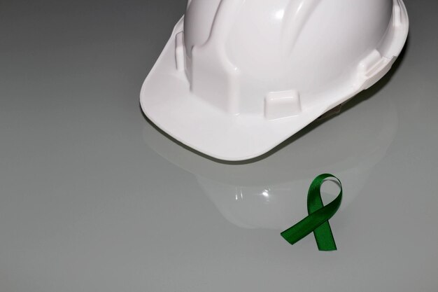 Mês de abril verde de conscientização sobre a importância da segurança no trabalho fita verde e capacete branco