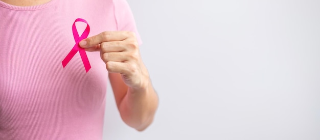 Foto mês de conscientização do câncer de mama de outubro rosa mão de mulher segura fita rosa e usa camisa para apoiar a vida e a doença das pessoas mês nacional dos sobreviventes do câncer conceito do dia da mãe e do dia mundial do câncer