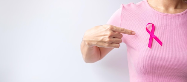 Mês de conscientização do câncer de mama de outubro rosa mão de mulher segura fita rosa e usa camisa para apoiar a vida e a doença das pessoas Mês nacional dos sobreviventes do câncer Conceito do dia da mãe e do dia mundial do câncer