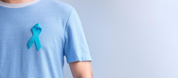 Mês de conscientização do câncer de próstata de novembro azul Homem de camisa azul com a mão segurando a fita azul para apoiar a vida e a doença das pessoas Saúde Homens internacionais Pai Diabetes e Dia Mundial do câncer