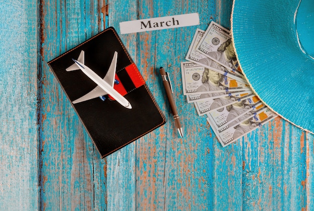 Foto mês de março do ano civil, viagens de turismo, planejamento de avião, lápis, chapéu azul e caderno com preparação para viajar