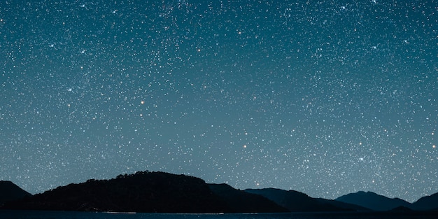 Mês em um céu estrelado de fundo refletido no mar.