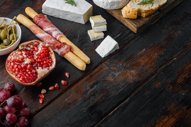 Mesa de aperitivos con antipasti, en madera oscura.