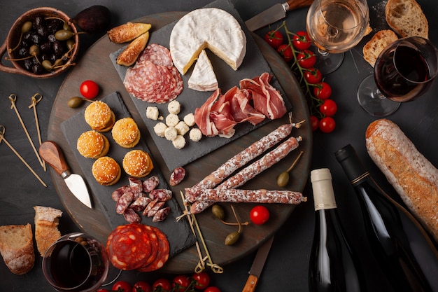 Mesa de aperitivos con diferentes antipasti, queso, embutidos, snacks y vino.