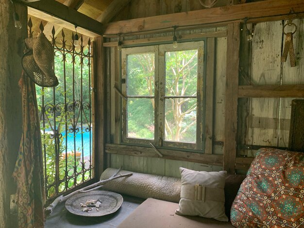 Foto mesa y árboles vistos a través de la ventana de la casa