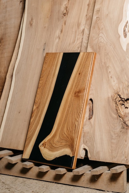 Mesa artesanal exclusiva de madeira maciça e resina epóxi sobre fundo de tábuas de madeira