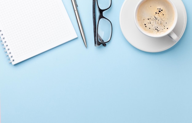 Mesa azul com suprimentos e café.