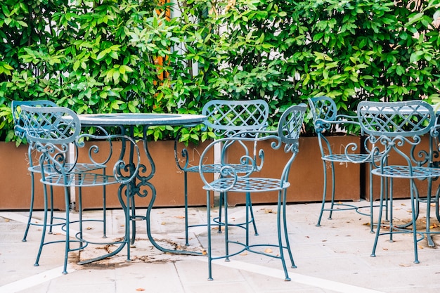 Una mesa azul y una silla de metal de un café de verano en la calle.