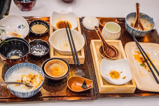 Mesa bagunçada após a refeição no restaurante japonês Conceitos de sobras de refeição de acabamento sujo