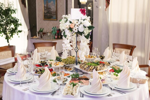 Mesa de banquete de boda servida con platos en el restaurante.