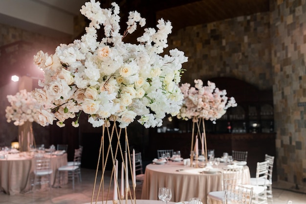 Mesa de banquete de bodas en la preparación del restaurante antes del banquete Flores claras y rosadas