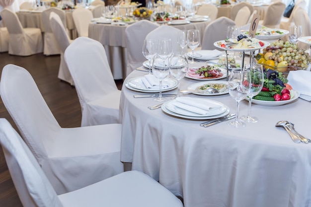 mesa de banquete sin gente servida con comida y utensilios para comer tenedores cucharas vasos