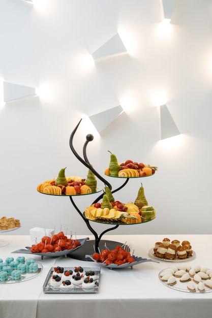 Mesa bellamente servida con frutas y dulces Buffet festivo para invitados con una variedad de delicias