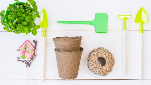 Foto una mesa blanca con herramientas de jardinería que incluye una maceta de jardín, una maceta de jardín y una maceta de jardín.