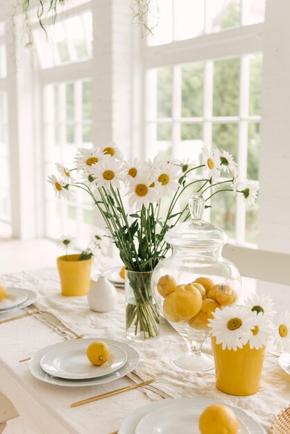 Mesa blanca de primavera verano bellamente servida con muchos limones y manzanilla