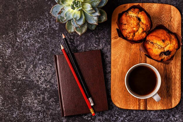 Mesa con bloc de notas, flores y café.