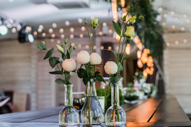 Mesa de boda decorada al estilo boho. Decorado con detalles, arreglo de flores de peonía en jarrones de vidrio.