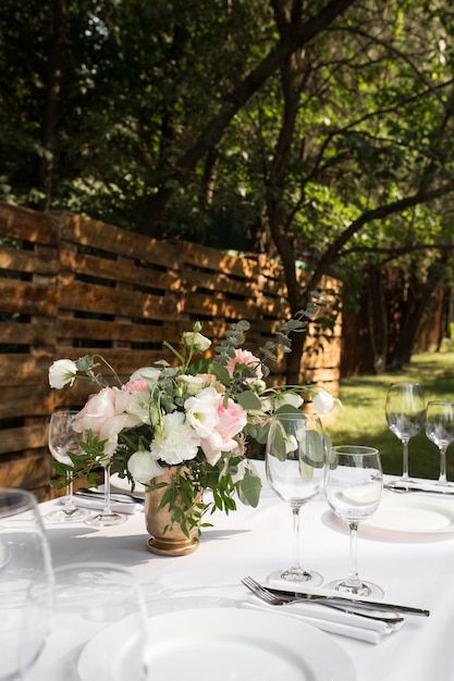 Mesa de boda decorada con flores frescas en un jarrón de latón