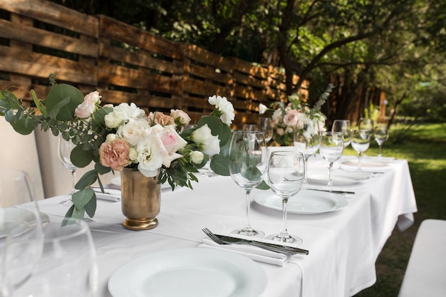 Mesa de boda decorada con flores frescas en un jarrón de latón