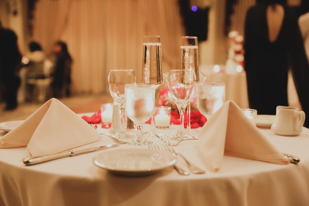 Una mesa en una boda con un mantel rojo y vasos encima