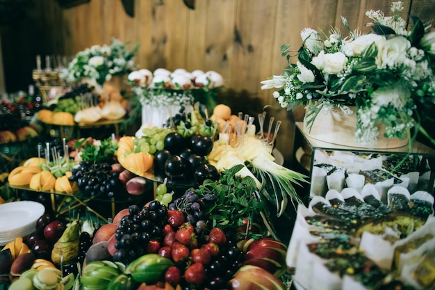 Mesa de bodas con aperitivos y frutas y postres en el catering de la ceremonia