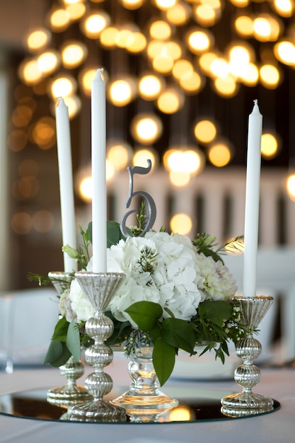 La mesa para bodas está decorada con flores frescas y velas blancas.