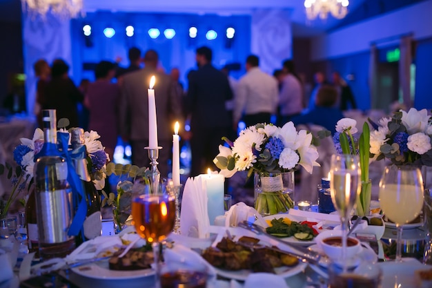 Mesa de bodas en el restaurante. Gente bailando en el fondo de la mesa nupcial.