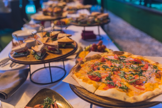 Mesa de buffet para un banquete sándwich y pizza.