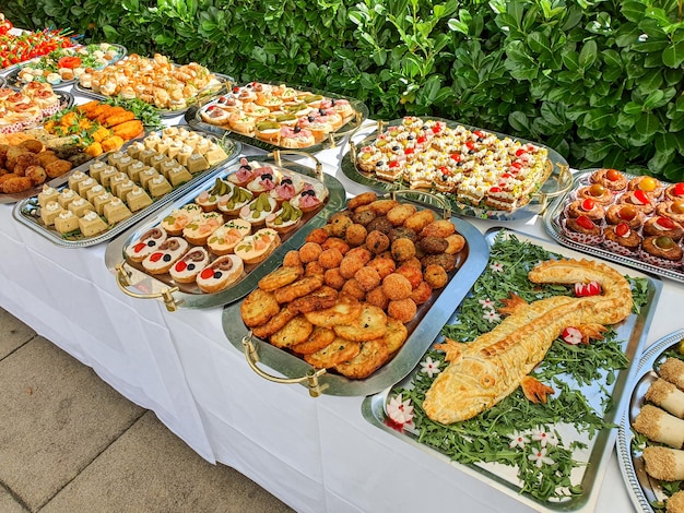 Una mesa de buffet con una variedad de alimentos que incluyen sándwiches y ensaladas.
