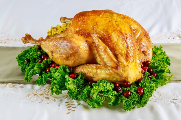 Mesa de cena de Acción de Gracias servida con pavo, decorada con col rizada y arándano. Concepto de vacaciones de año nuevo.