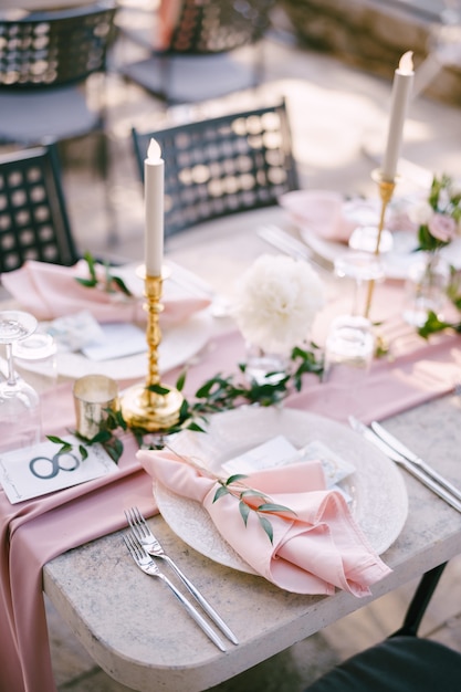 Mesa de cena de boda mesa de piedra de recepción con placas de corredor rosa con patrón y servilletas de trapo rosa