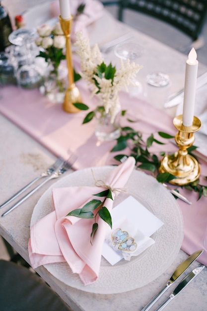 Mesa de cena de boda mesa de piedra de recepción con placas de corredor rosa con patrón y servilletas de trapo rosa