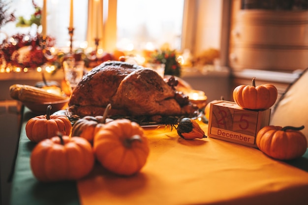 Mesa de cena navideña de acción de gracias con calabazas y calendario de madera en decoración de otoño