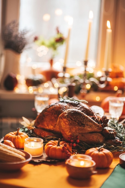 Mesa de cena navideña de acción de gracias con decoración de otoño y calabazas