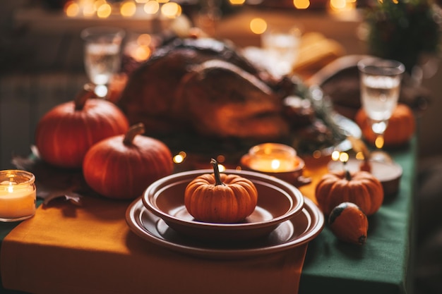 Mesa de cena navideña de acción de gracias con decoración de otoño y calabazas