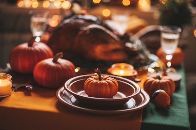 Mesa de cena navideña de acción de gracias con decoración de otoño y calabazas
