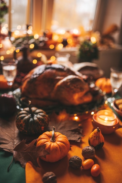 Mesa de cena navideña de acción de gracias con decoración de otoño y calabazas