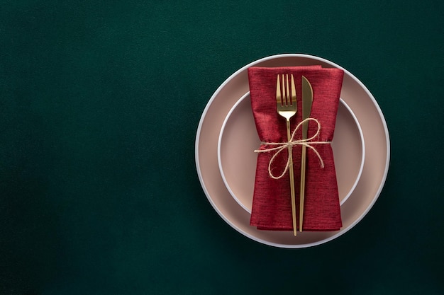 Mesa de cena con platos vacíos y cubiertos dorados sobre una tarjeta de fondo verde oscuro o una plantilla de menú con espacio de copia para el diseño plano de texto Vista superior Vajilla de cerámica moderna Vajilla de moda