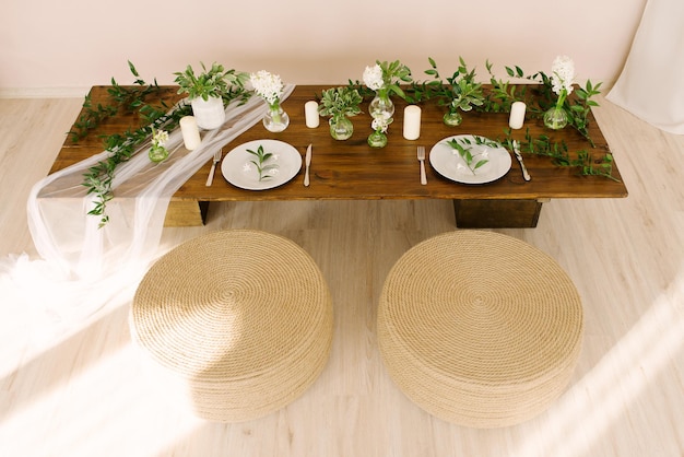 Mesa de centro en estilo boho o rústico decorada y servida para unas vacaciones o cenas y otomanas