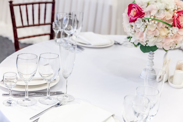 Foto mesa chique posta para jantar com composição de flores em restaurante, interior luxuoso