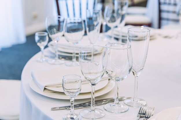 Mesa chique posta para jantar com copos de guardanapo no restaurante, fundo interior luxuoso