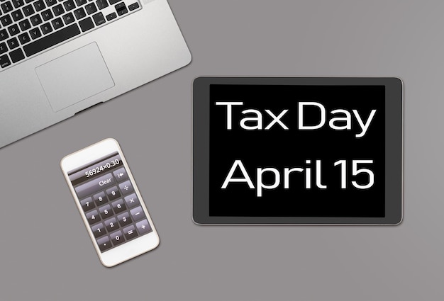Mesa cinza limpa para laptop smartphone e tablet com mensagem para o dia fiscal de 2019 em 15 de abril