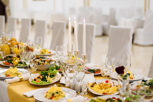 Mesa coberta com comida e pratos com copos em uma toalha de mesa em um restaurante