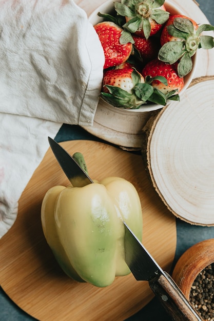 Mesa de cocción con un pimiento cortado en medio cuchillo y algunos condimentos