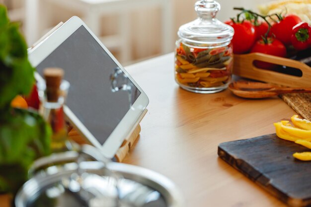 Foto mesa de cocina con comida y tableta digital de cerca