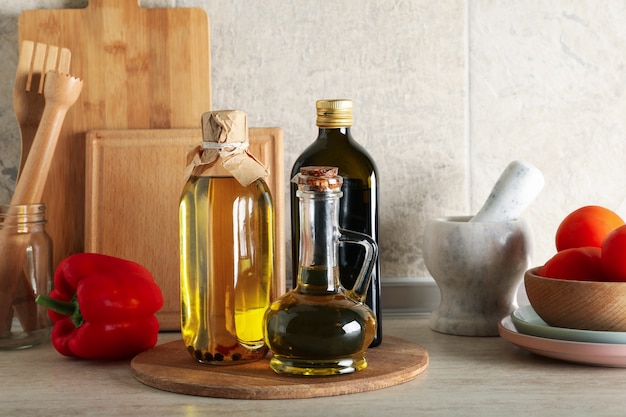 Mesa de cocina con diferentes suministros y botellas con aceite.